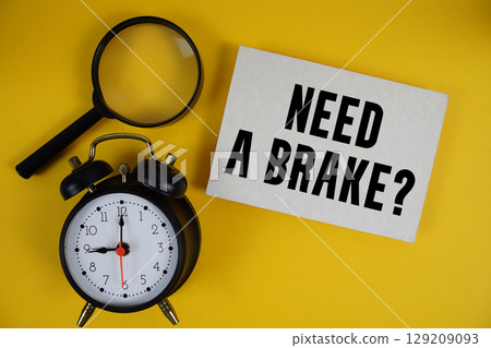 Need a Brake? text written on paper with magnifying glass and alarm clock on yellow background 129209093