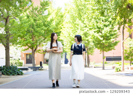 走沿一條沿途有樹的路的婦女 129209343