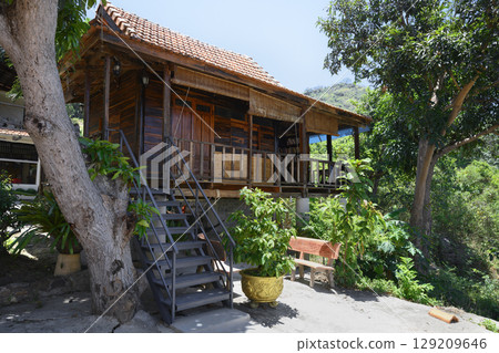 Wooden house under a tropical tree in Buddhist Hua Da Bao Monastery 129209646