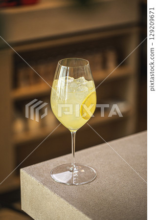 Refreshing lemon cocktail with ice in wine glass 129209671