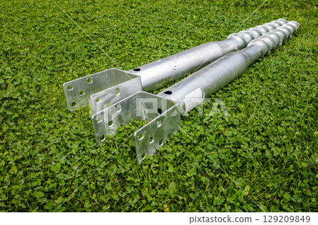 Galvanized Ground Anchors with Mounting Brackets on Grass Surface 129209849