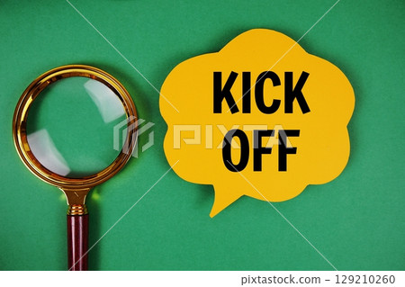 Kick Off text with speech bubble and magnifying glass on green background 129210260
