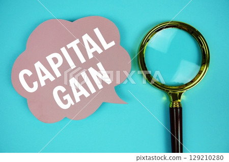 Capital Gain text with speech bubble and magnifying glass on blue background Capital Gain text with speech bubble and magnifying glass on blue background 129210280