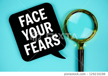 Face Your Fears text with speech bubble and magnifying glass on blue background Face Your Fears text with speech bubble and magnifying glass on blue background 129210286