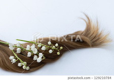 Hair with white merry bells flowers. Closeup, on a white background. Hair with white merry bells flowers. Closeup, on a white background. 129210784