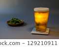 A glass of beer and edamame beans at night 129210911