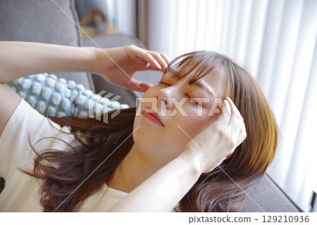 Facial expression of a young woman suffering from a headache 129210936