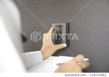 A man ringing the intercom for a home inspection 129210961