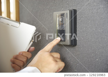 A scene of a man in work clothes visiting a house 129210963
