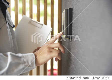 A scene of a man in work clothes visiting a house 129210965