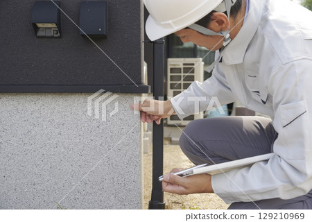 一名男子正在檢查房屋地基 129210969