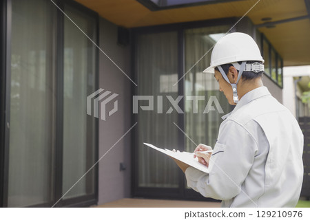 Male architect checking a home Male architect checking a home 129210976