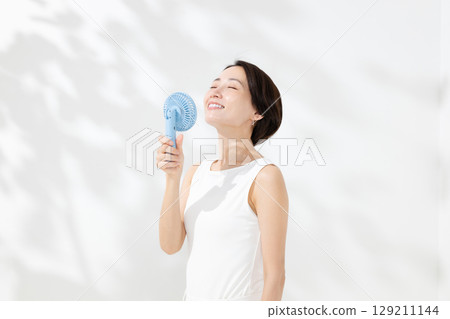 A woman who uses a handy fan 129211144