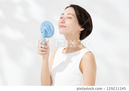A woman who uses a handy fan A woman who uses a handy fan 129211145