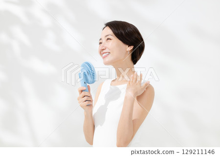 A woman who uses a handy fan 129211146