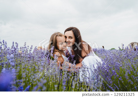 The mother and daughter enjoy a warm moment in the lavender field 129211325