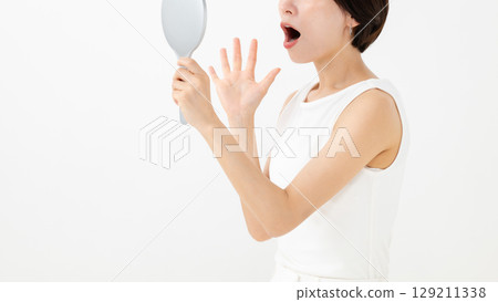 A woman watching a mirror 129211338