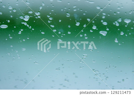 Raindrop attached to the windshield of the car 129211473