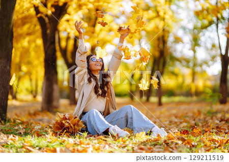 Smiling woman enjoying autumn weather. Rest, relaxation, lifestyle concept. 129211519