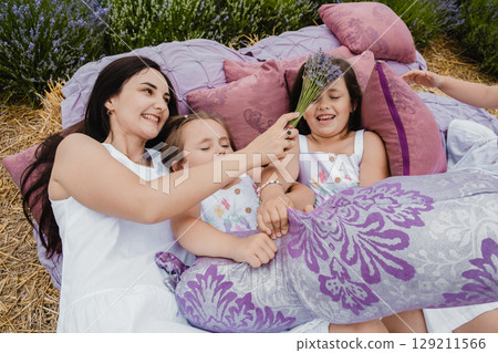 The happy mother and her three daughters snuggle close to each other, creating a perfect family scene The happy mother and her three daughters snuggle close to each other, creating a perfect family scene 129211566