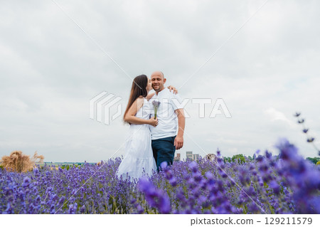 A lavender field in golden light. A brutal man gently embraces his beloved 129211579