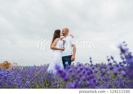 A lavender field in golden light. A brutal man gently embraces his beloved A lavender field in golden light. A brutal man gently embraces his beloved 129211580