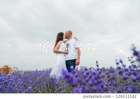 A field of lavender spreads around a couple in love 129211582
