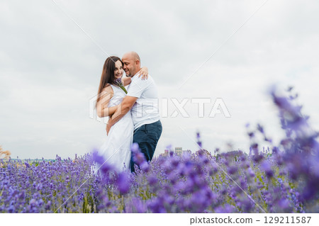 A man's strong arms wrap around the girl's waist 129211587