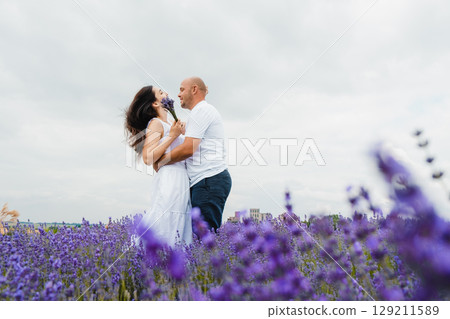A young couple in love stands listening to the silence of the lavender field and the beating of their hearts 129211589