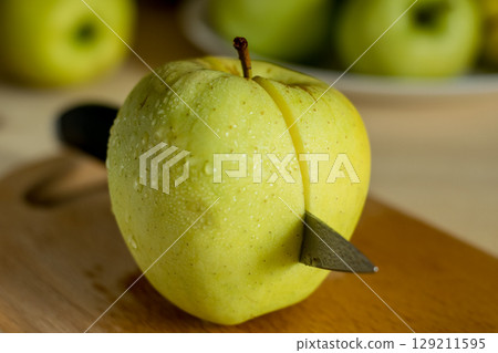 A beautiful green apple with a knife A beautiful green apple with a knife 129211595