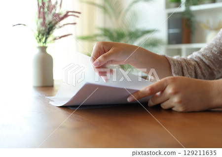 Woman hand throwing sugar in a coffee cup at home 129211635