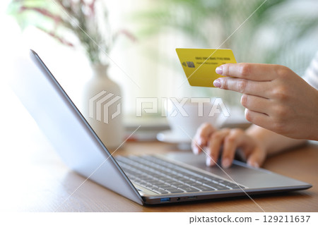Woman hand throwing sugar in a coffee cup at home 129211637