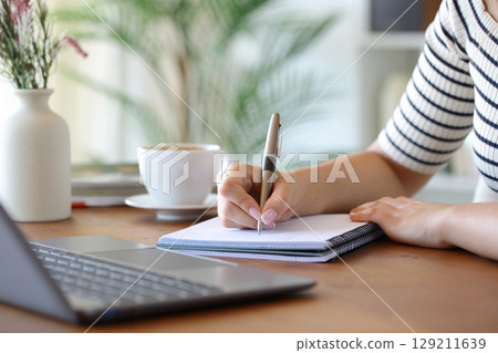 Woman hand throwing sugar in a coffee cup at home 129211639