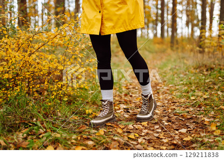 Female legs in boots walking through fallen trees in autumn park. Nature, travel concept. 129211838