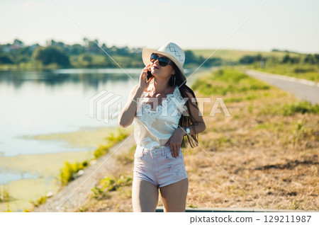 The summer day by the lake complements the image of the girl in the white hat and light outfit The summer day by the lake complements the image of the girl in the white hat and light outfit 129211987