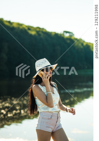 A young girl in shorts, a T-shirt and a hat 129211998