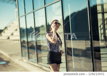 The girl wearing glasses near the glass looks completely focused on the conversation The girl wearing glasses near the glass looks completely focused on the conversation 129212031