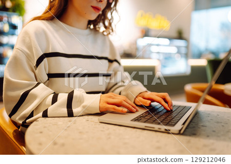 A young woman is engaged in typing on a laptop. Cyber security. Business, Freelance, Shopping 129212046