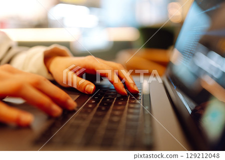 A young woman is engaged in typing on a laptop. Cyber security. Business, Freelance, Shopping 129212048