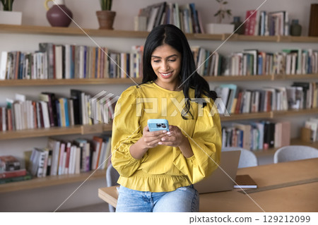 Young Indian woman, office employee or university student using smartphone Young Indian woman, office employee or university student using smartphone 129212099