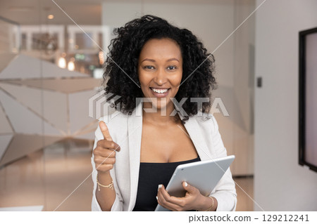 Happy young Black female entrepreneur showing thumb up to camera 129212241