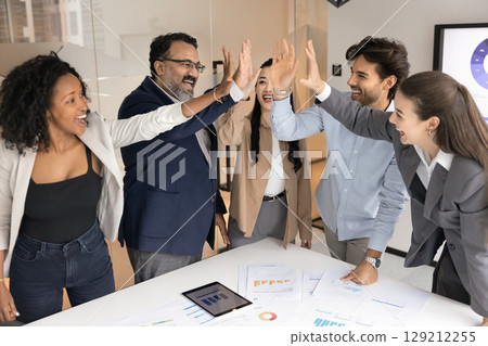 Motivated multicultural professionals group celebrating team success with high fives Motivated multicultural professionals group celebrating team success with high fives 129212255