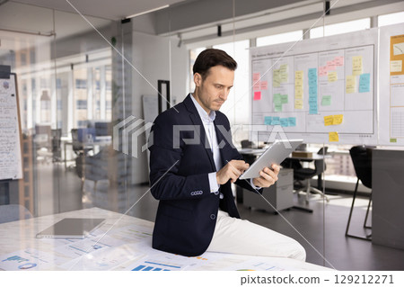 Man preparing presentation on tablet for upcoming meeting Man preparing presentation on tablet for upcoming meeting 129212271