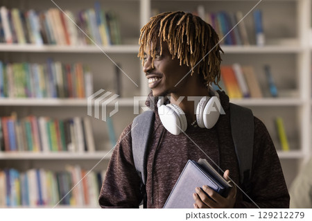 Portrait joyful hipster male student standing in classroom looking away 129212279