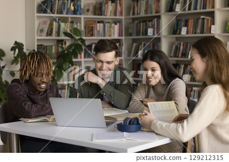 Multiethnic gen z students use notebook in library for studying Multiethnic gen z students use notebook in library for studying 129212315