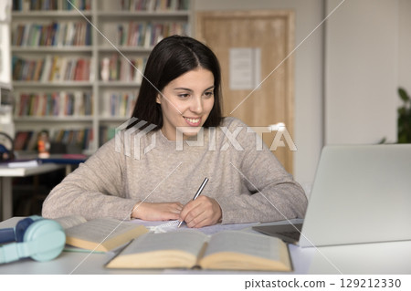 Smiling young student girl enjoy productive self studying online Smiling young student girl enjoy productive self studying online 129212330