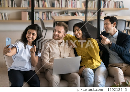 Colleagues looking at smartphone while take selfie pictures in office Colleagues looking at smartphone while take selfie pictures in office 129212343