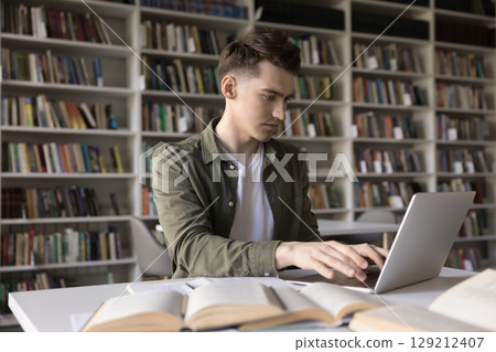 Busy young college student write essay on notebook at library Busy young college student write essay on notebook at library 129212407