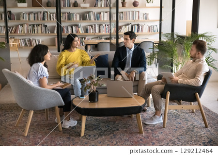 Group of four multinational professionals engaged in collaborative discussion 129212464
