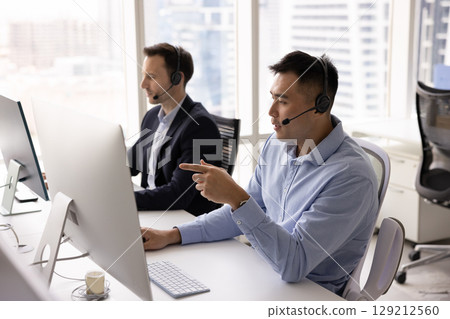 Two men wearing headsets conducting virtual collaboration, consulting client remotely 129212560